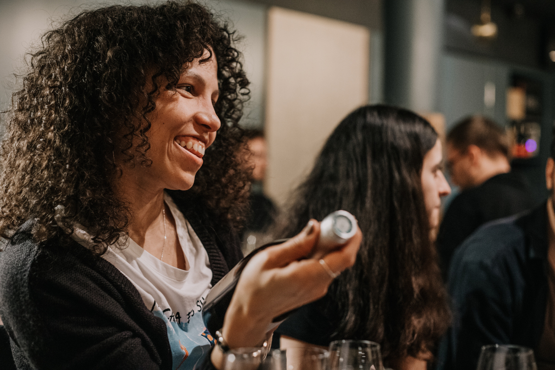 Yira during a gathering holding a bottle of wine