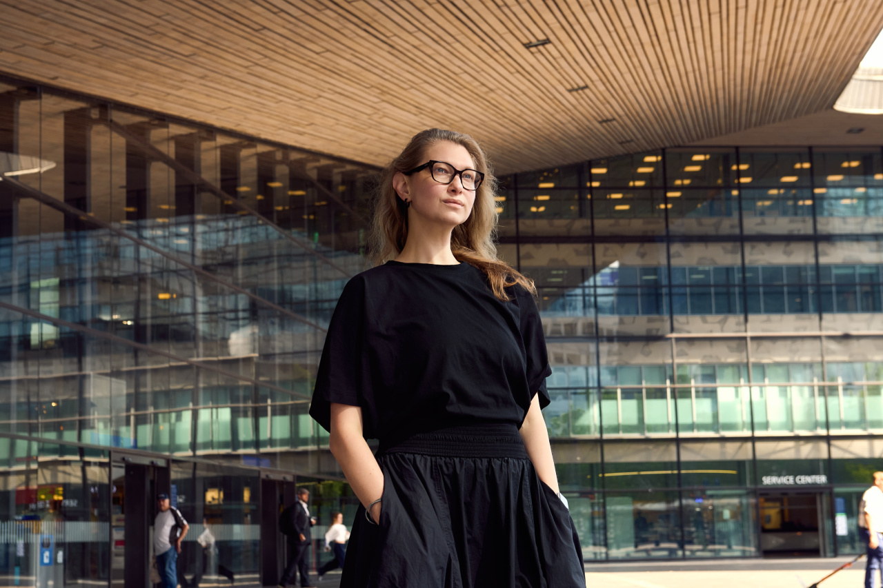 Angelina Severino, Lebara's Global Design & UX Lead, standing in front of a modern glass building with a sweeping wood-slatted ceiling.