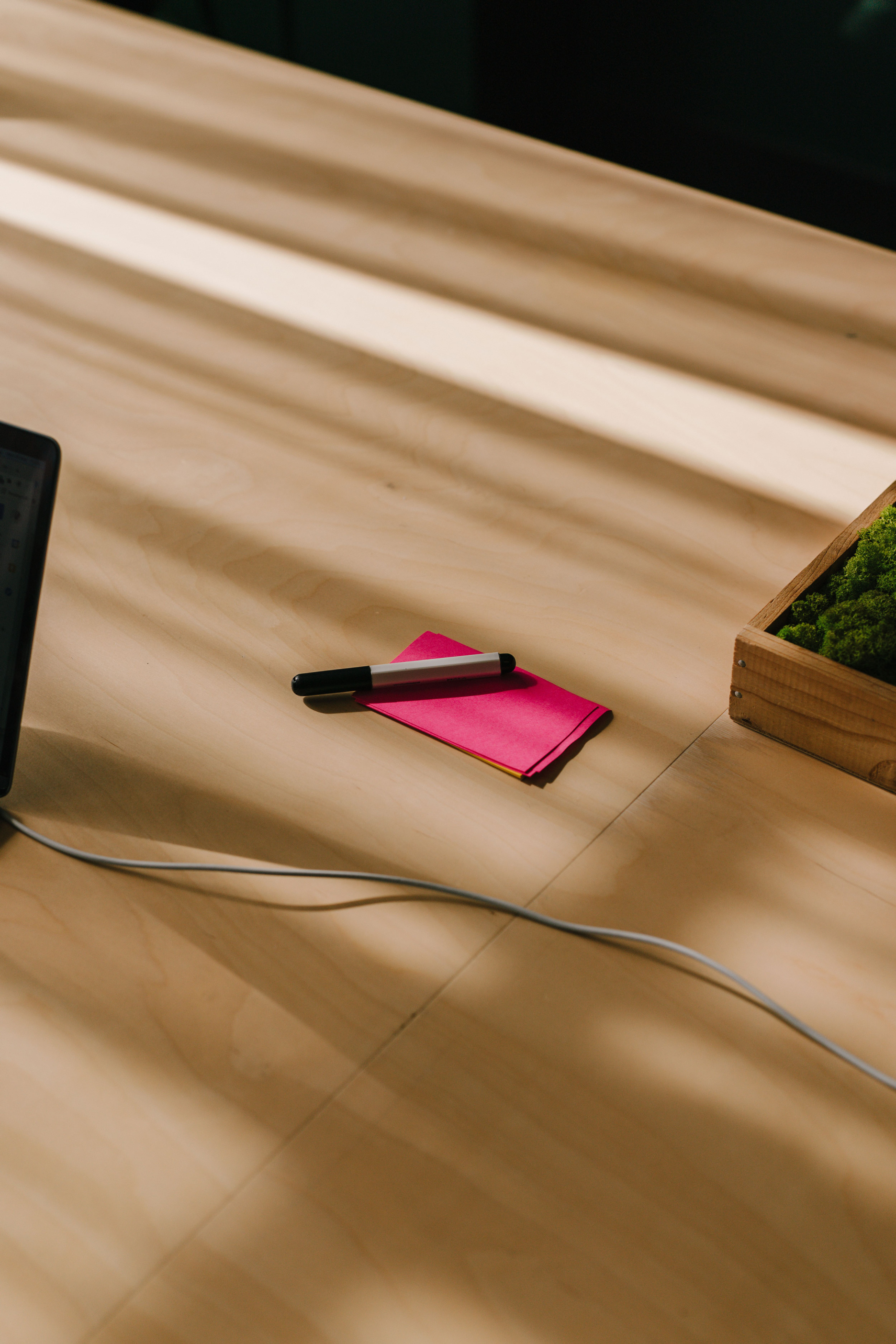 Pink post it and black and white marker on the table