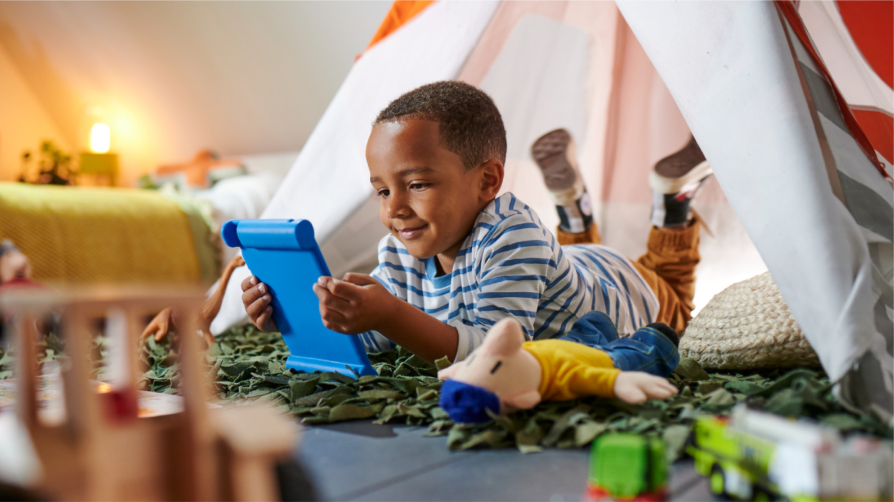Child playing with iPad in a bedroom