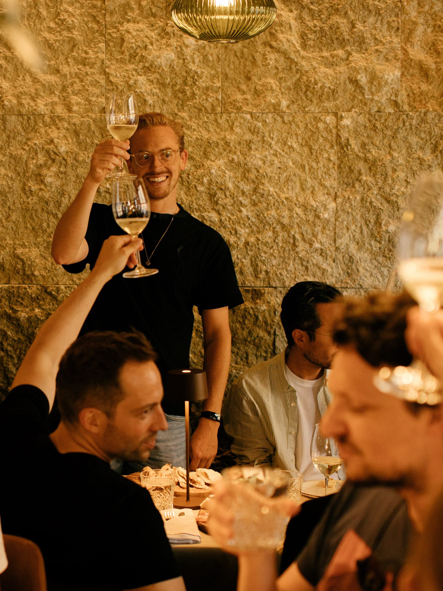 Verve Co-Founder Roman Stikkelorum smiling and toasting with wine glasses at a Tallinn restaurant