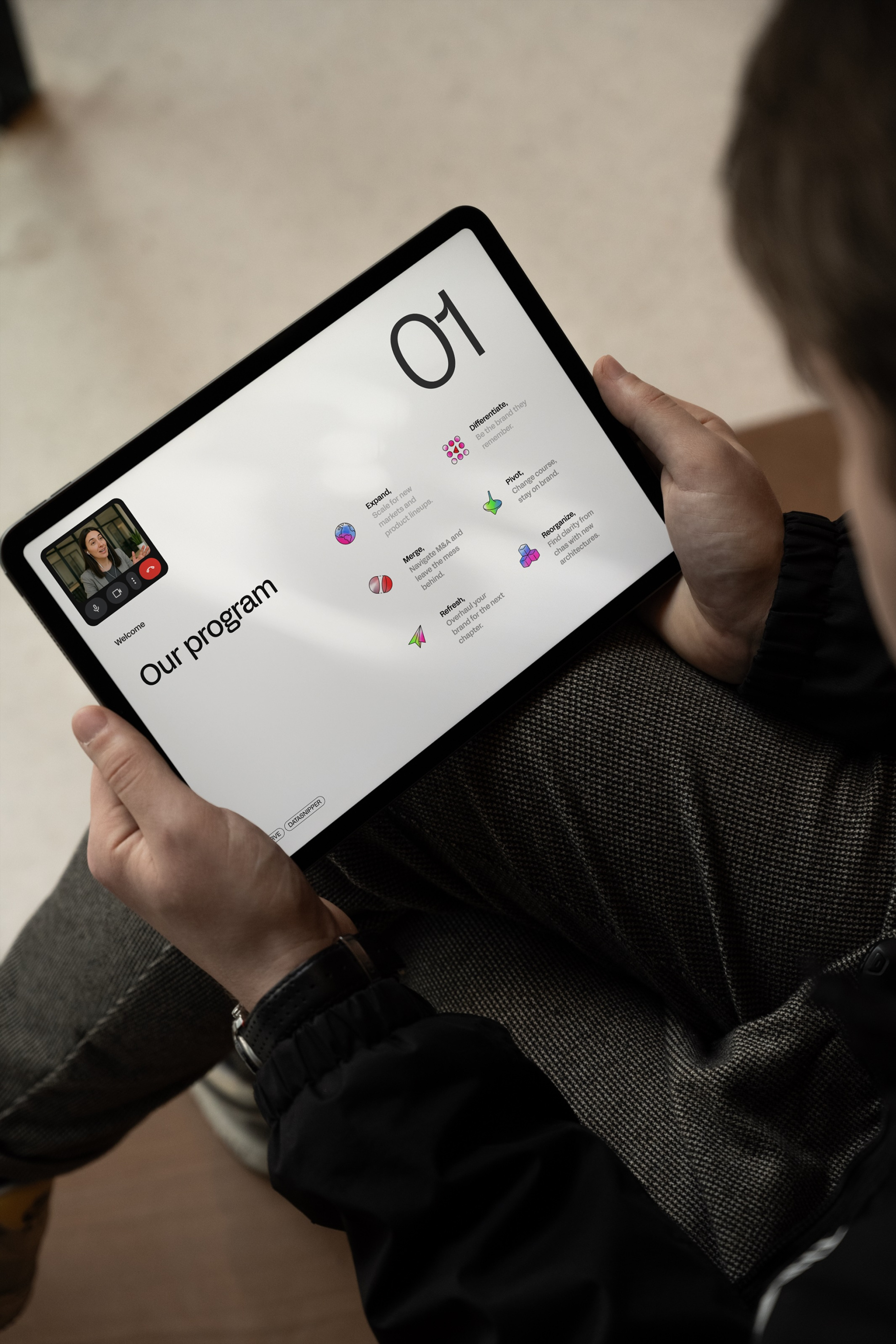 Person holding a tablet displaying a Verve Agency strategy presentation slide titled Our Program