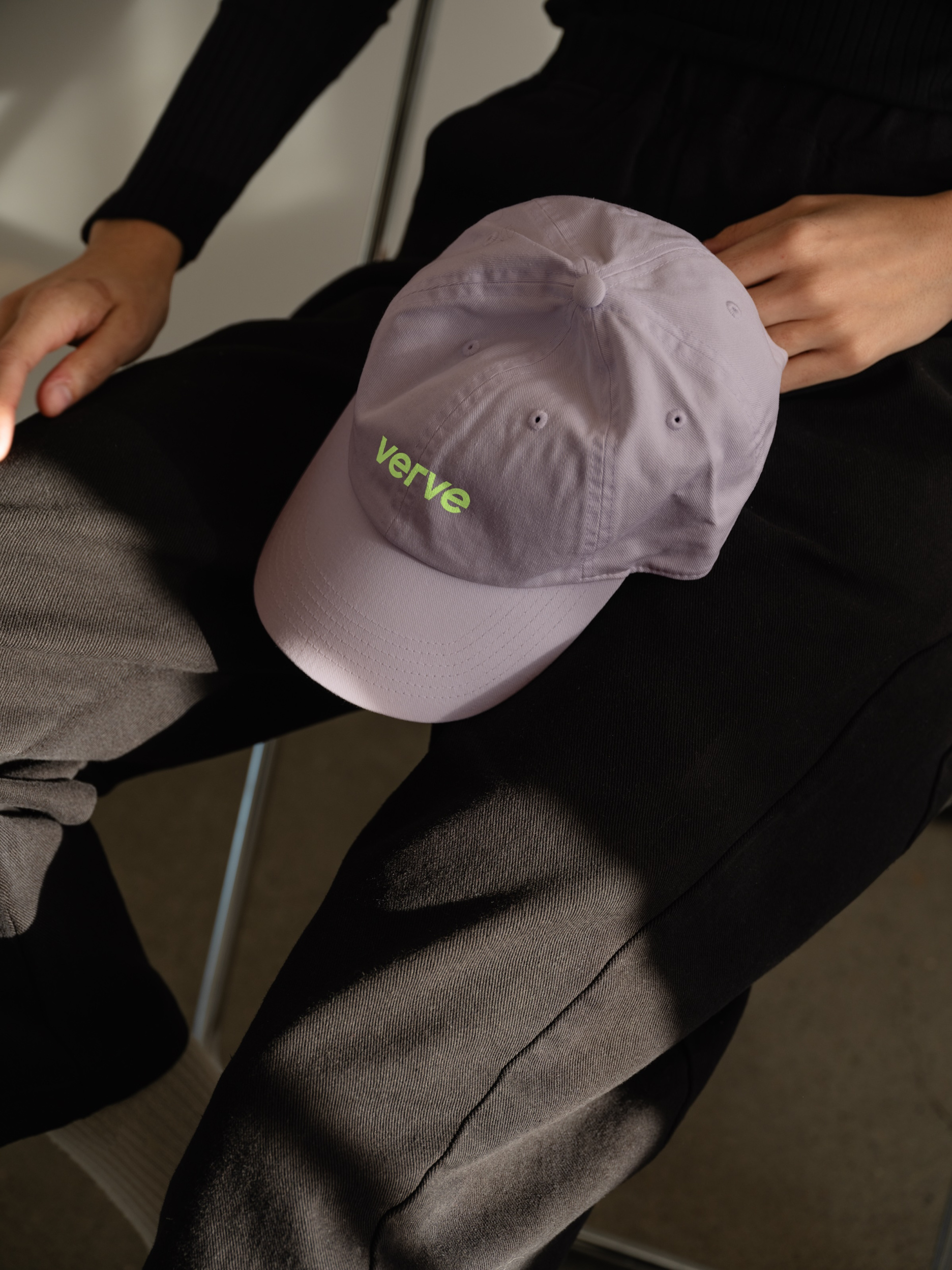 Verve Agency custom brand merchandise mockup displaying light purple baseball cap with lime green logo