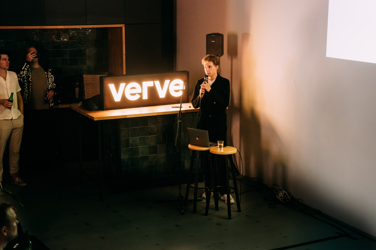 erve Digital Designer Bram Naus presenting on stage in front of an illuminated Verve sign