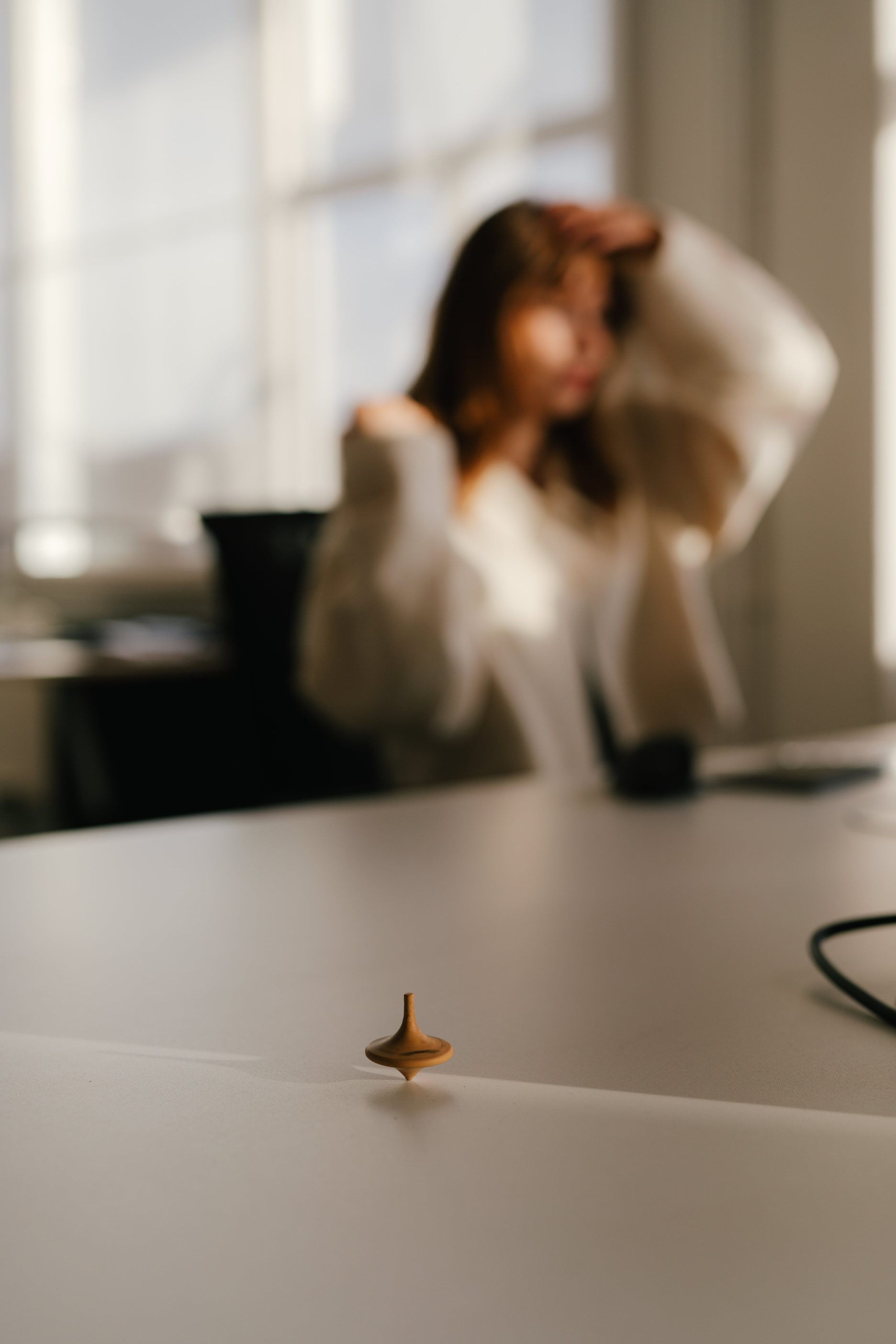 Sarah on the background the focus in on Verve branded wood spinning top on the office desk